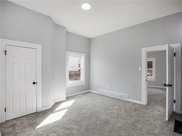 unfurnished bedroom featuring carpet, visible vents, and baseboards