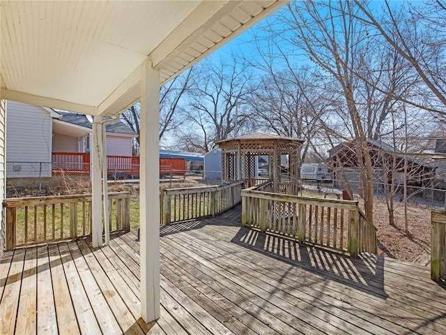 wooden deck featuring an outbuilding and fence