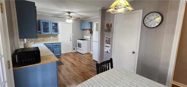 kitchen featuring white appliances, blue cabinets, a ceiling fan, and a sink