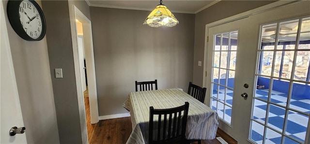 dining area with crown molding, wood finished floors, and baseboards