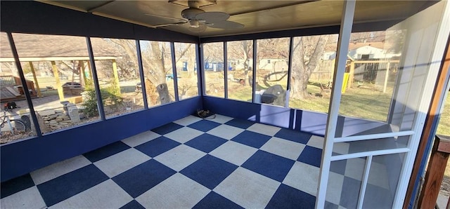 unfurnished sunroom featuring ceiling fan