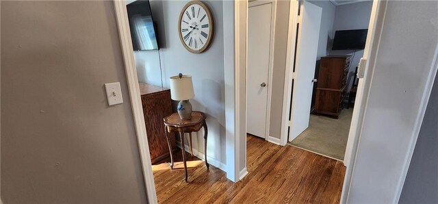 corridor with baseboards and wood finished floors