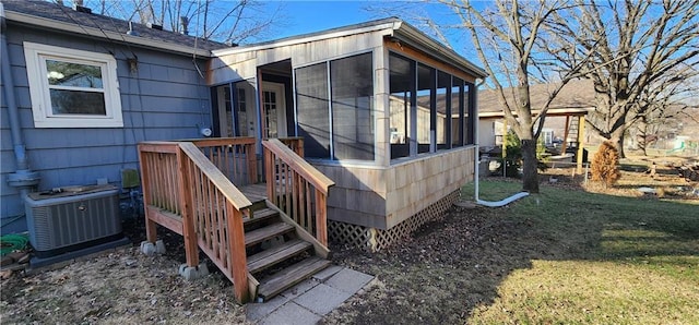 wooden deck featuring fence, central AC, a lawn, and a sunroom