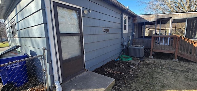 view of property exterior with central AC unit and a sunroom