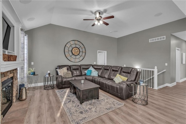 living room featuring visible vents, wood finished floors, baseboards, ceiling fan, and vaulted ceiling