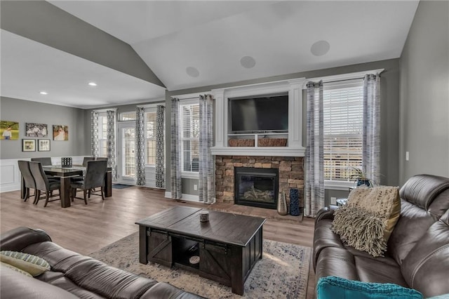 living area with recessed lighting, lofted ceiling, light wood-style flooring, and a fireplace