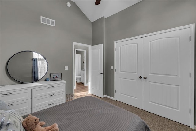 carpeted bedroom featuring visible vents, baseboards, a closet, high vaulted ceiling, and a ceiling fan