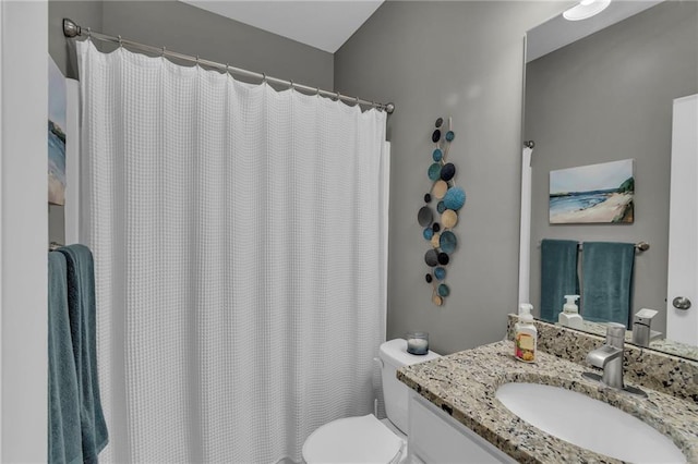 bathroom with toilet, vanity, and a shower with curtain