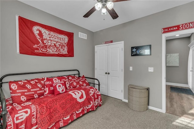 carpeted bedroom featuring visible vents, baseboards, a closet, and ceiling fan