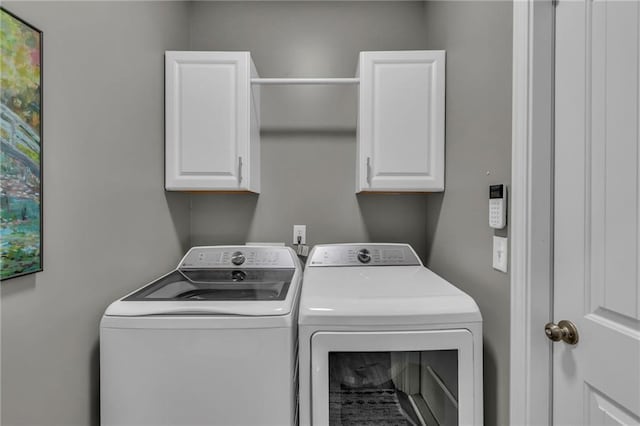 washroom featuring cabinet space and washing machine and dryer