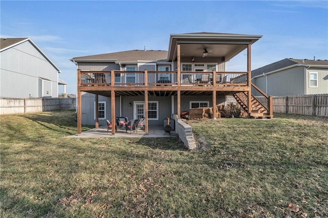 rear view of house featuring a fenced backyard, a lawn, a wooden deck, and a patio