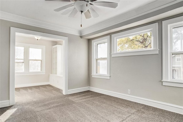 spare room featuring baseboards, a ceiling fan, carpet, and ornamental molding