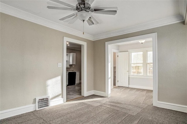 spare room with visible vents, baseboards, carpet, and ornamental molding