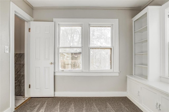 unfurnished room with baseboards and carpet