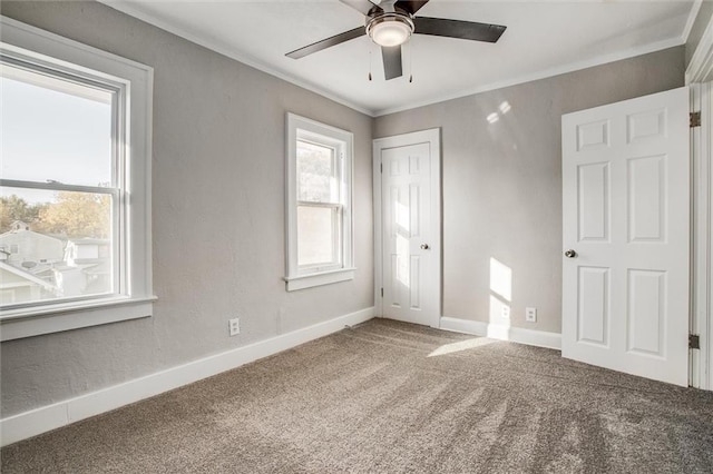 unfurnished bedroom with crown molding, carpet, baseboards, and ceiling fan