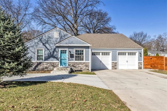 view of front of home with a garage, stone siding, driveway, and fence