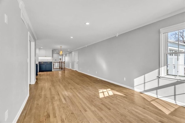 unfurnished living room with recessed lighting, baseboards, light wood-type flooring, and ornamental molding