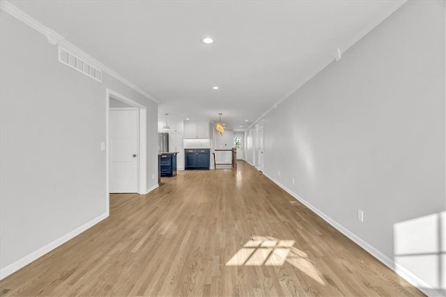 unfurnished living room with visible vents, baseboards, ornamental molding, recessed lighting, and light wood-style flooring