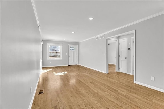 interior space featuring visible vents, light wood-style flooring, baseboards, and ornamental molding