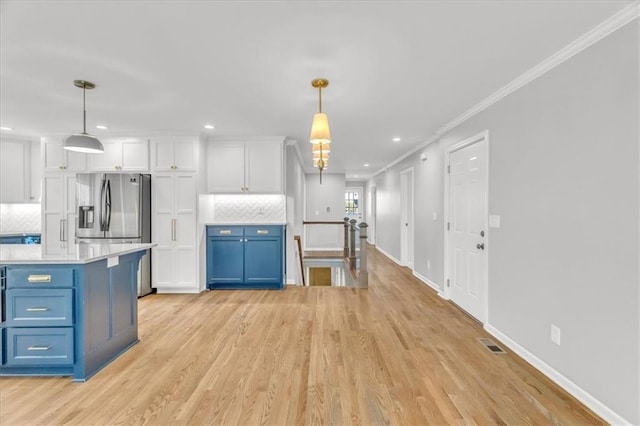 kitchen with white cabinetry, light countertops, blue cabinets, and ornamental molding