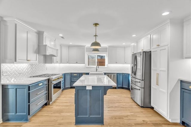 kitchen featuring appliances with stainless steel finishes, light countertops, and blue cabinets