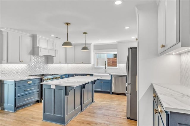 kitchen featuring a kitchen bar, custom range hood, a sink, stainless steel appliances, and light wood-style floors