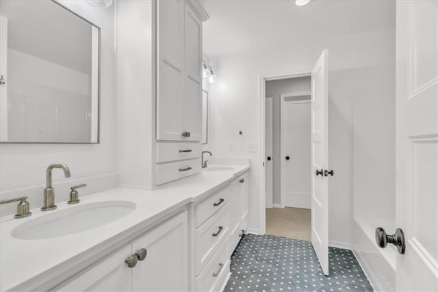 full bathroom featuring double vanity, a shower, and a sink