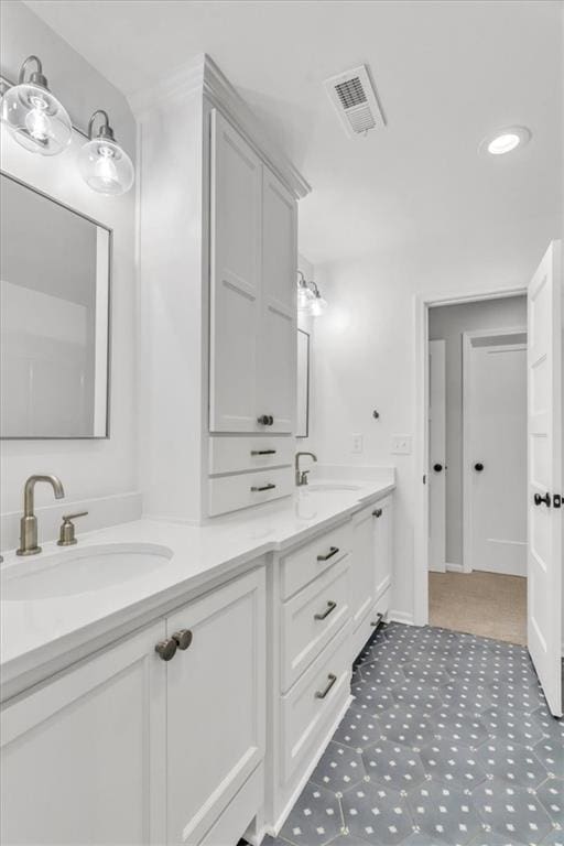 bathroom featuring double vanity, visible vents, and a sink