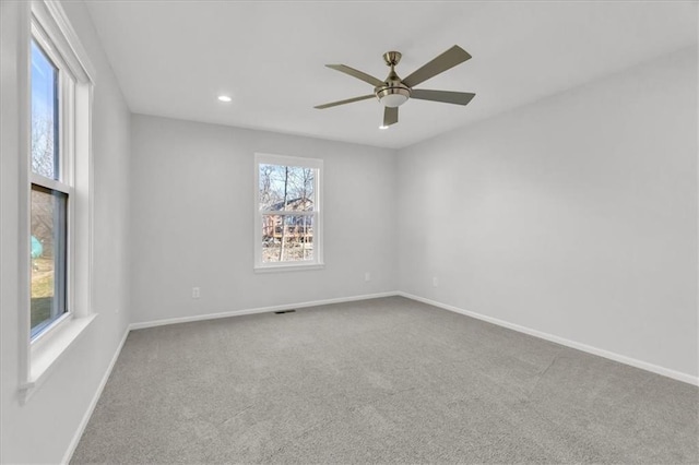 empty room with a wealth of natural light, baseboards, carpet floors, and ceiling fan