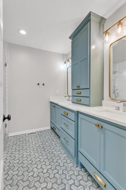 bathroom featuring tile patterned floors, a sink, double vanity, baseboards, and walk in shower