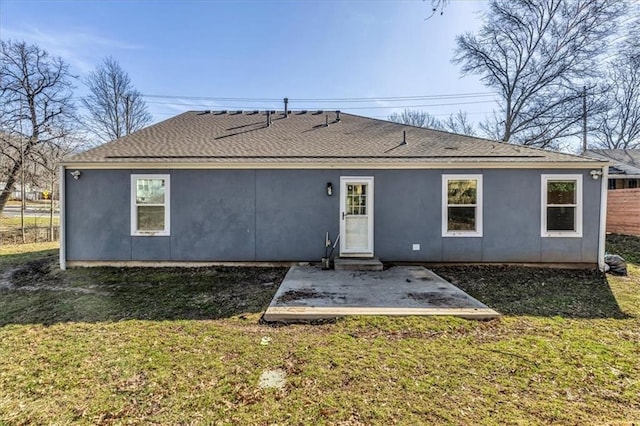 rear view of house featuring a yard, stucco siding, and a patio area