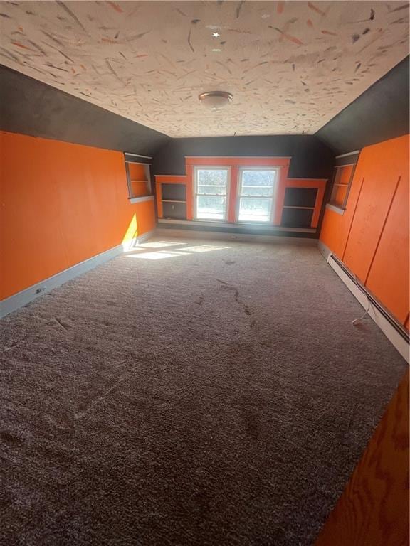 spare room featuring built in features, baseboards, lofted ceiling, and carpet floors