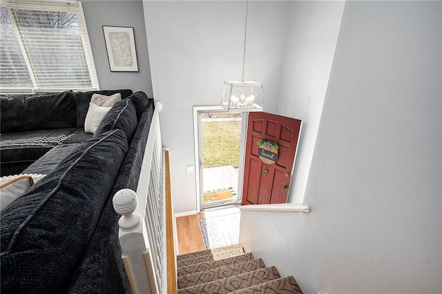 staircase with a notable chandelier and wood finished floors