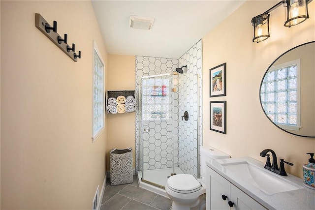 bathroom featuring vanity, a shower stall, toilet, and tile patterned floors