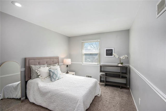 carpeted bedroom with visible vents and baseboards