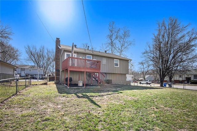 back of house featuring a lawn, a deck, stairs, fence, and a chimney