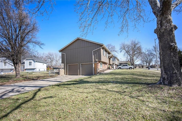 view of side of home featuring fence, a residential view, concrete driveway, a yard, and an attached garage