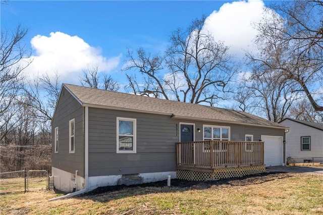 view of front facade featuring a front yard, fence, an attached garage, concrete driveway, and a deck