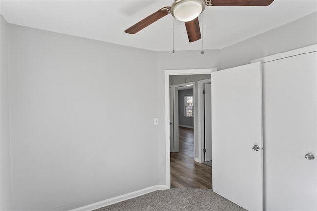 unfurnished bedroom featuring a closet, baseboards, a ceiling fan, and carpet flooring