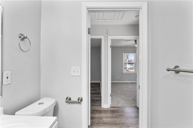 bathroom with vanity, wood finished floors, baseboards, ceiling fan, and toilet