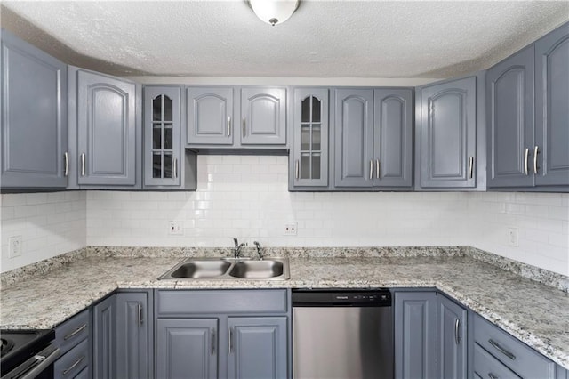 kitchen with tasteful backsplash, appliances with stainless steel finishes, glass insert cabinets, and a sink