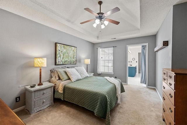 bedroom featuring baseboards, ceiling fan, a textured ceiling, a raised ceiling, and light carpet