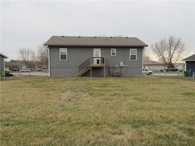 back of property featuring a lawn, central AC, and fence