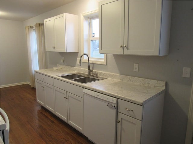 kitchen with white dishwasher, dark wood-style flooring, a sink, light countertops, and white cabinets