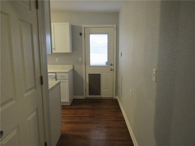 clothes washing area featuring dark wood-style floors and baseboards