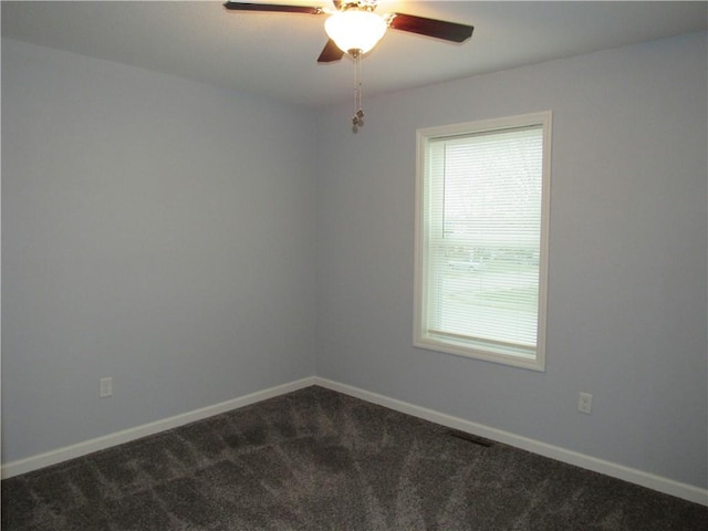 unfurnished room with baseboards, ceiling fan, and dark carpet