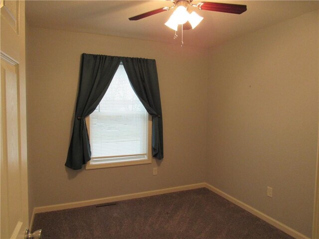 carpeted empty room with visible vents, baseboards, and ceiling fan