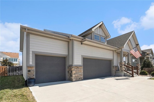 view of front of home featuring board and batten siding, fence, a garage, and driveway