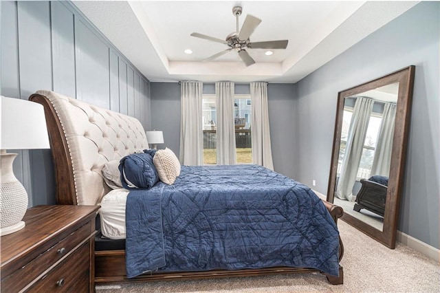 bedroom featuring baseboards, ceiling fan, a tray ceiling, carpet flooring, and recessed lighting