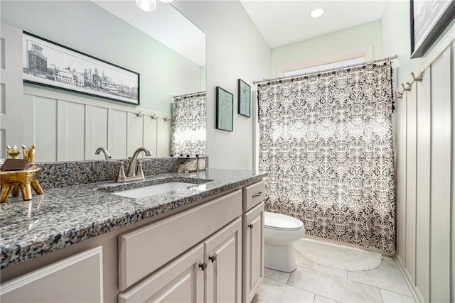 bathroom featuring tile patterned flooring, a shower with shower curtain, toilet, and vanity